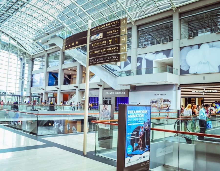 Explore the vibrant interior of Singapore's iconic shopping mall featuring modern architecture and bustling activity.